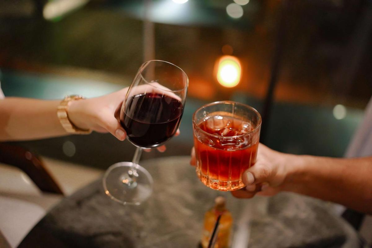 two people holding a glass of red wine at Radisson Blu Hotel Amritsar in Amritsar