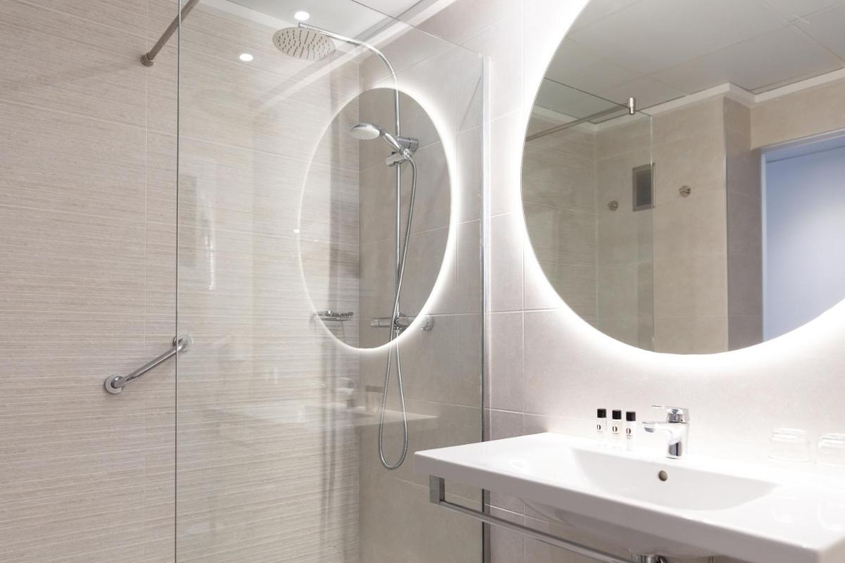 Un baño con ducha, lavabo y espejo. en Hotel Cap Negret, en Altea
