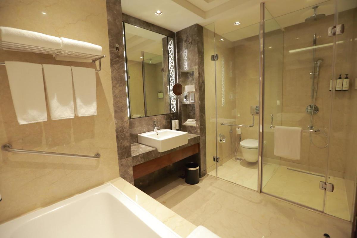 a bathroom with a tub and a sink and a shower at Crowne Plaza New Delhi Rohini by IHG in New Delhi a bathroom with a tub and a sink and a shower at Crowne Plaza New Delhi Rohini by IHG in New Delhi