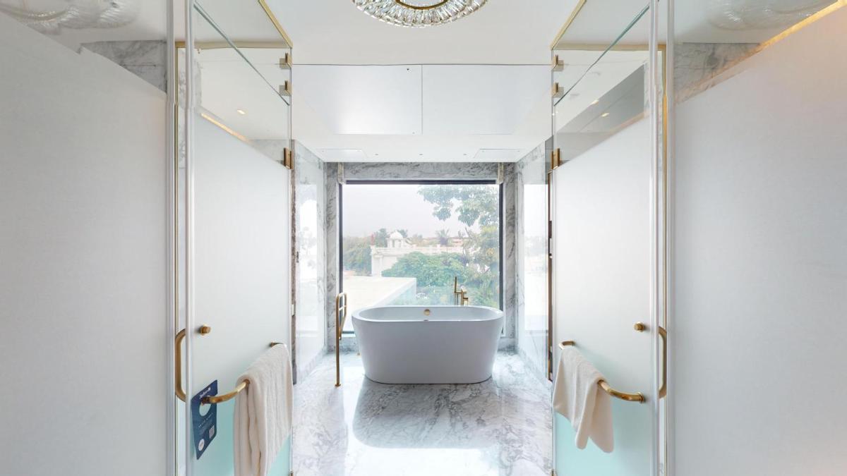 a bathroom with a tub and a large window at Radisson Blu Hotel & Suites GRT Chennai in Chennai