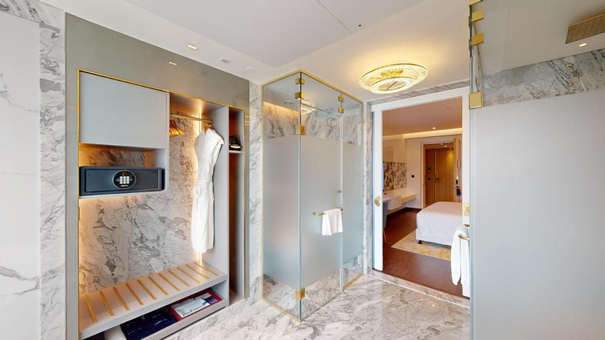 a bathroom with a walk in closet with a mirror at Radisson Blu Hotel & Suites GRT Chennai in Chennai