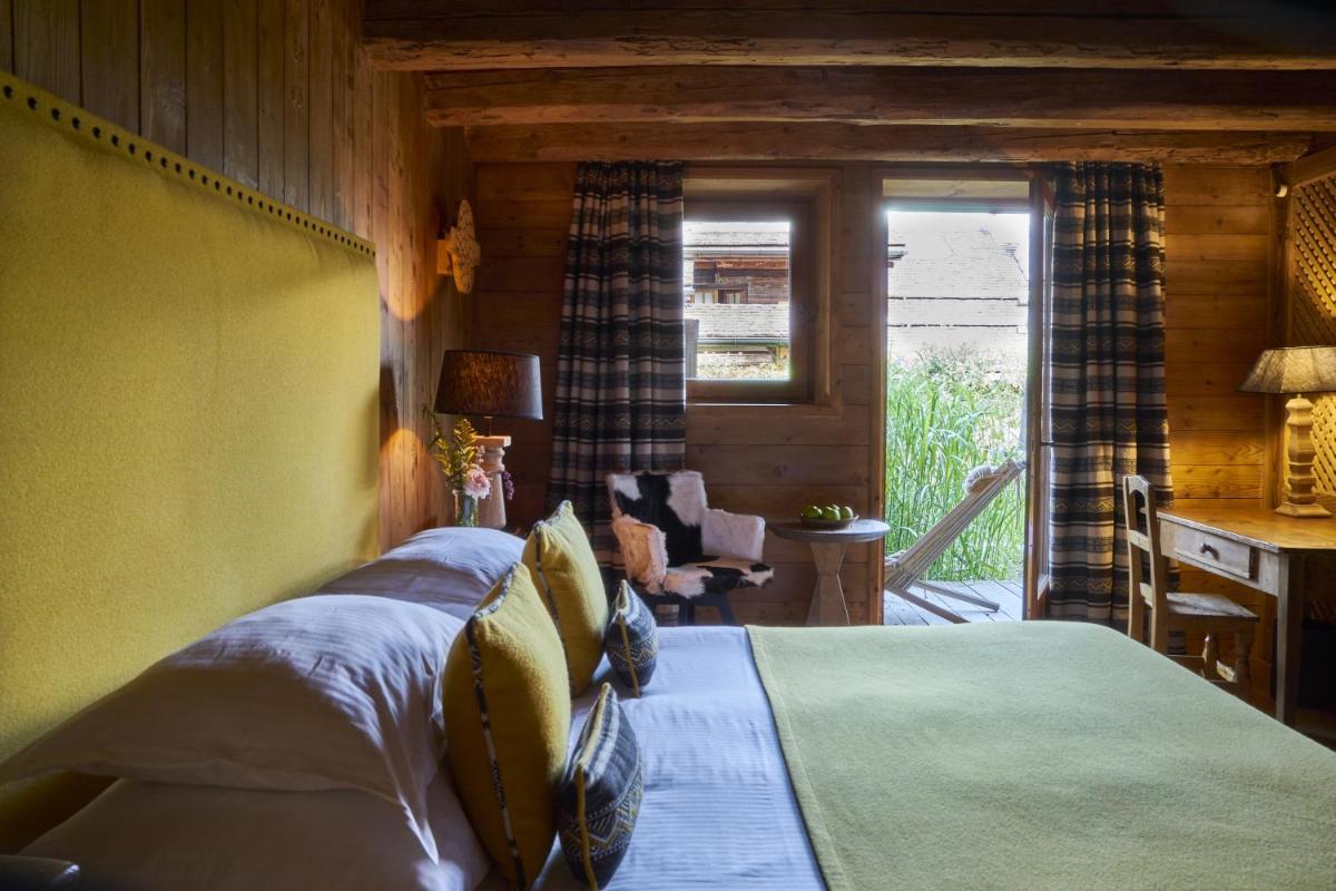 une chambre avec un lit, un bureau et une fenêtre dans l'établissement Les Fermes de Marie, à Megève