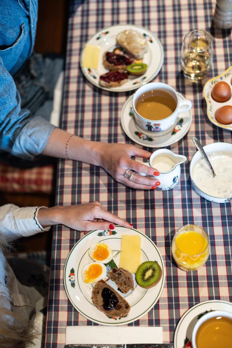 une personne assise à une table avec des assiettes de nourriture dans l'établissement Hôtel Arnold, à Itterswiller
