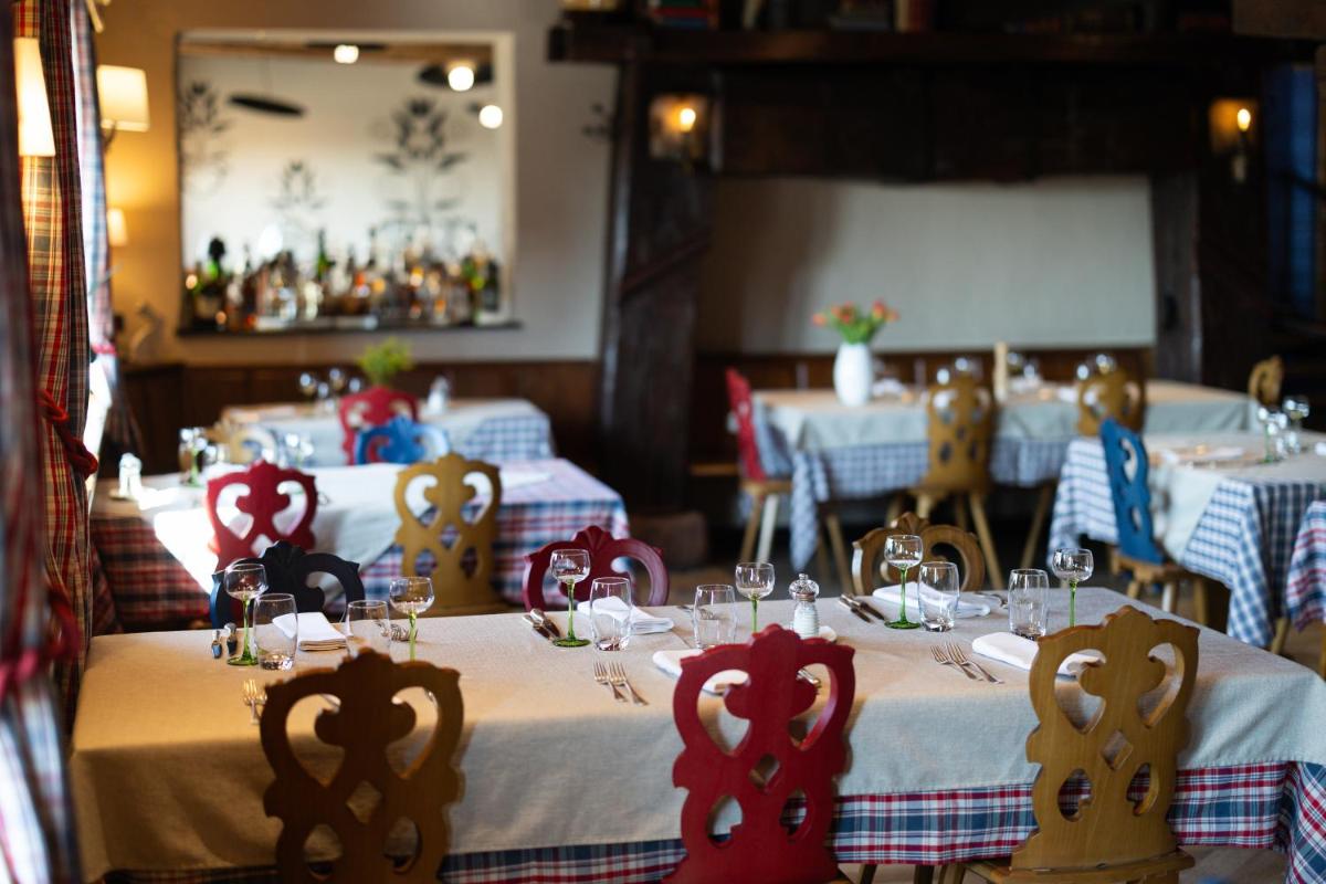 un restaurant avec deux tables recouvertes de nappes rouges et blanches dans l'établissement Hôtel Arnold, à Itterswiller