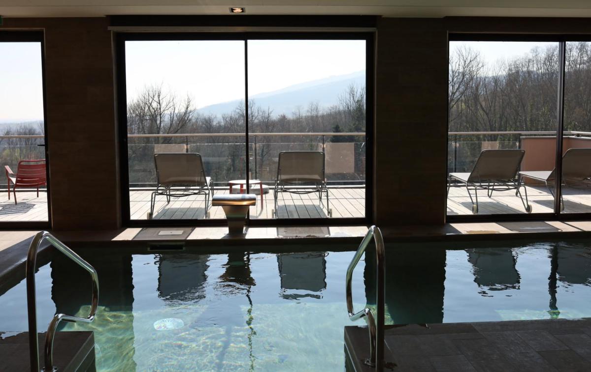 une grande piscine avec des chaises longues dans un bâtiment dans l'établissement Hôtel Arnold, à Itterswiller 108 autres photos
