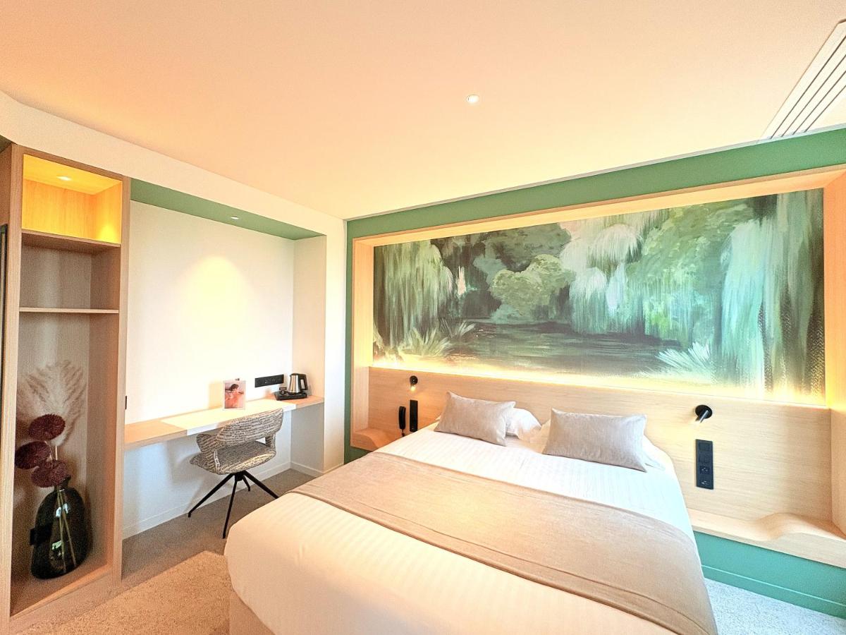 Un ou plusieurs lits dans un hébergement de l'établissement Brit Hotel Piscine & Spa - Fougères