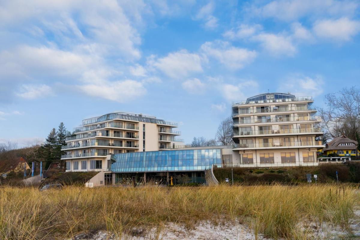 zwei hohe Gebäude vor einem Feld in der Unterkunft THE GRAND Ahrenshoop in Ahrenshoop