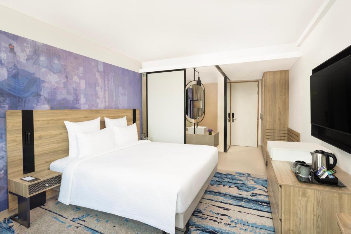 a hotel room with a bed and a tv at Novotel New Delhi City Centre in New Delhi a hotel room with a bed and a tv at Novotel New Delhi City Centre in New Delhi