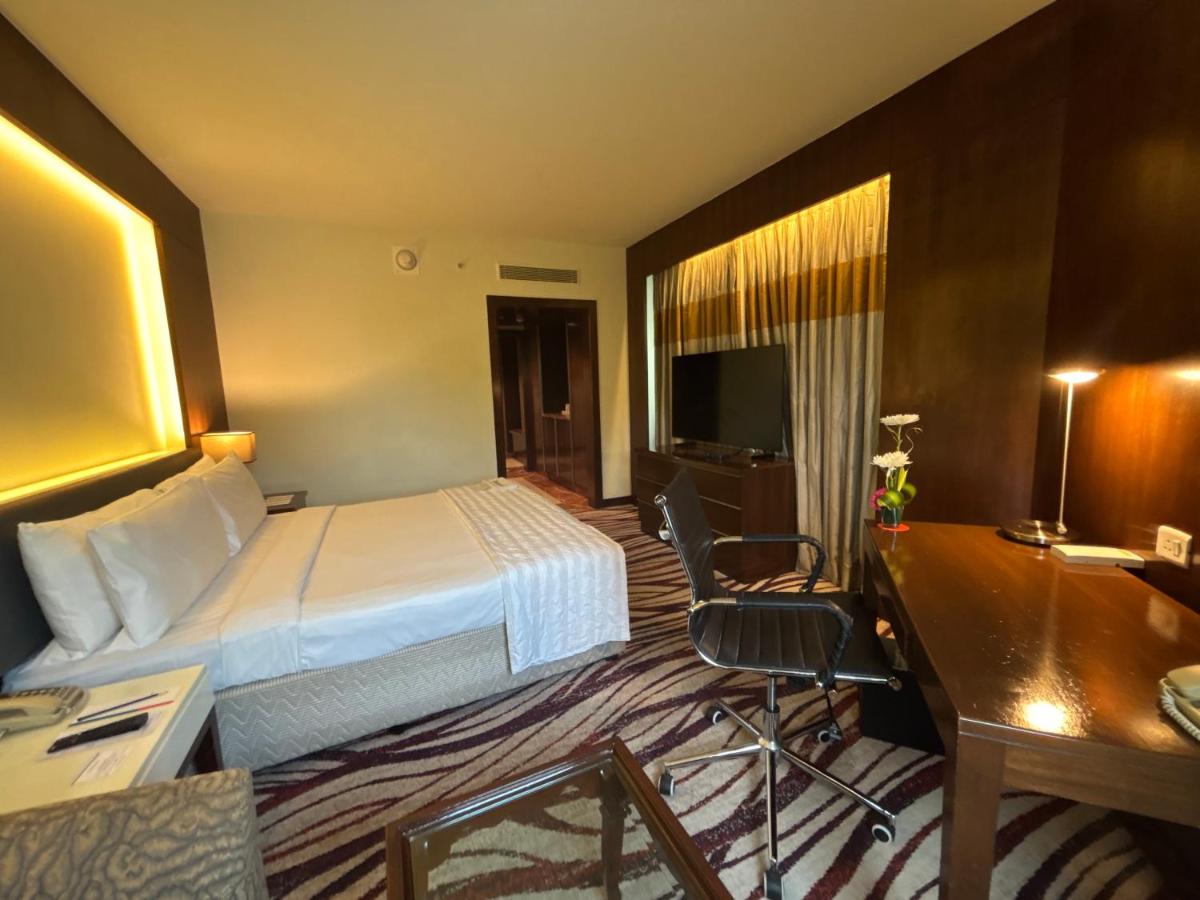 a hotel room with a bed and a desk at Le Royal Meridien Chennai in Chennai