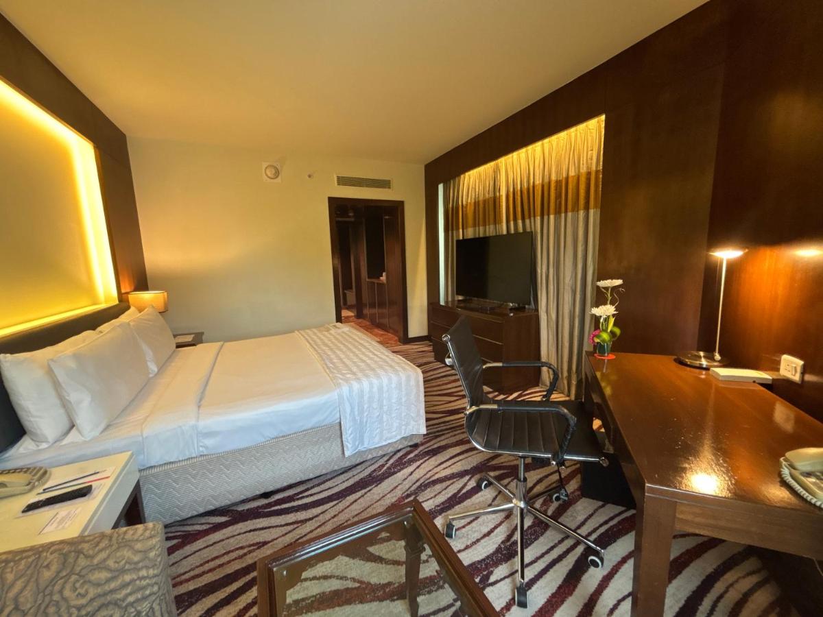 a hotel room with a bed and a desk at Le Royal Meridien Chennai in Chennai