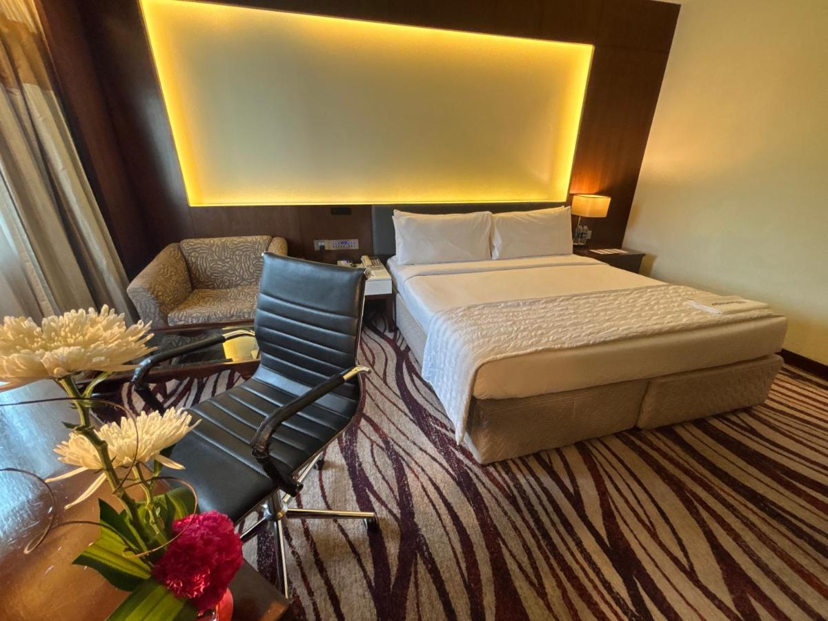 a hotel room with a bed and a chair at Le Royal Meridien Chennai in Chennai