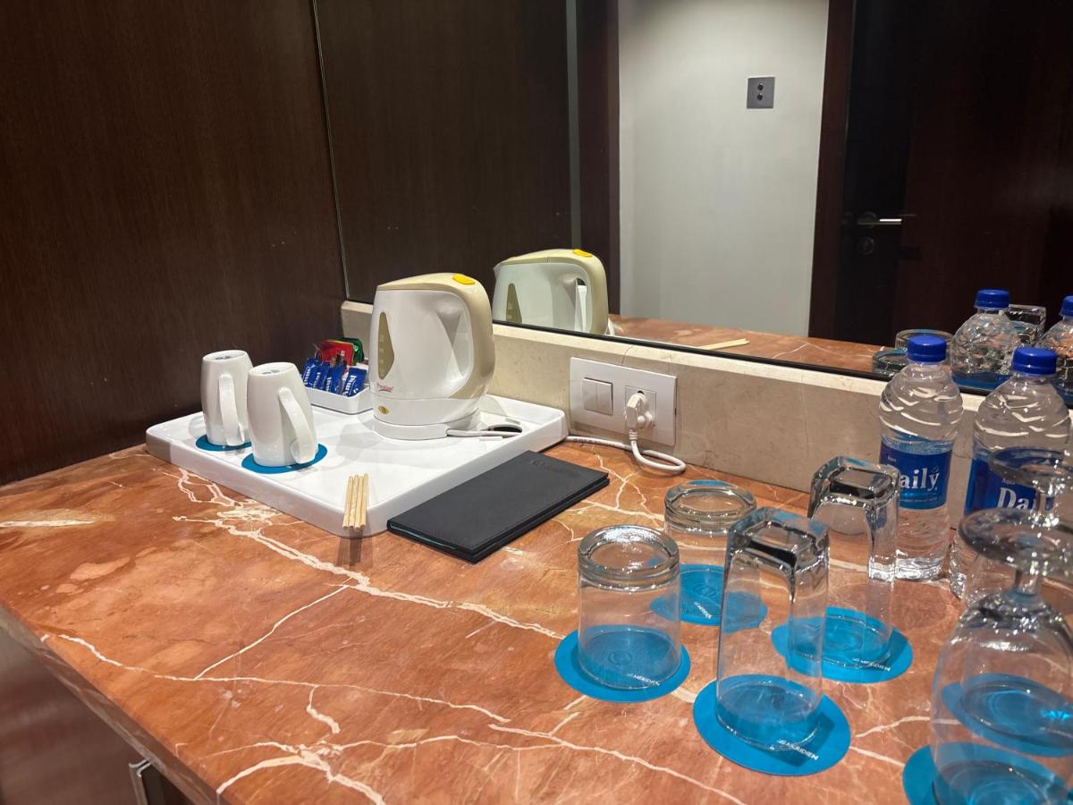 a counter with glasses and bottles of water on it at Le Royal Meridien Chennai in Chennai