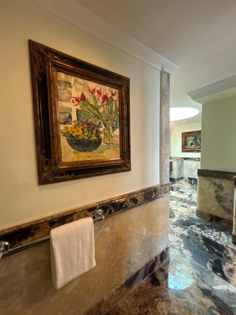 a bathroom with a painting of a bowl of fruit at Le Royal Meridien Chennai in Chennai