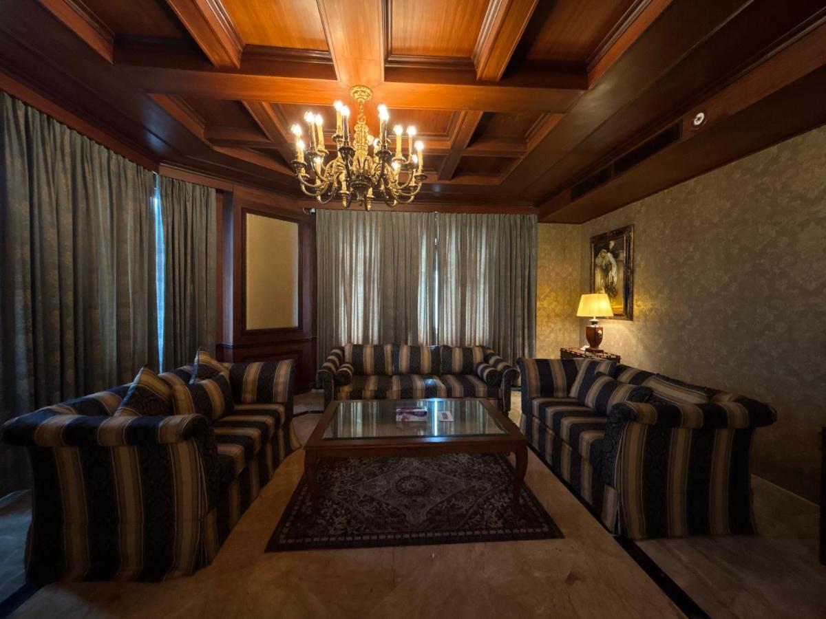 a living room with chairs and a table and a chandelier at Le Royal Meridien Chennai in Chennai