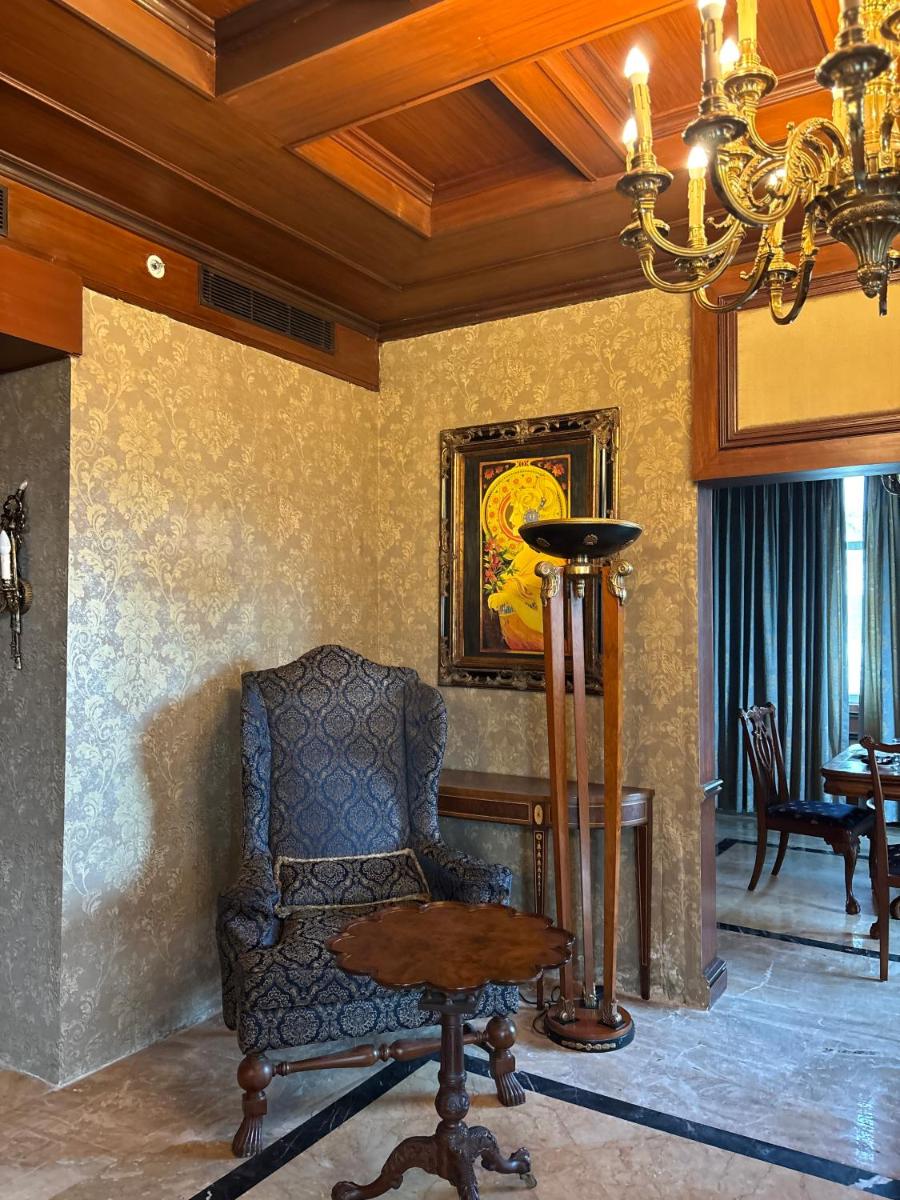 a living room with a chair and a table at Le Royal Meridien Chennai in Chennai