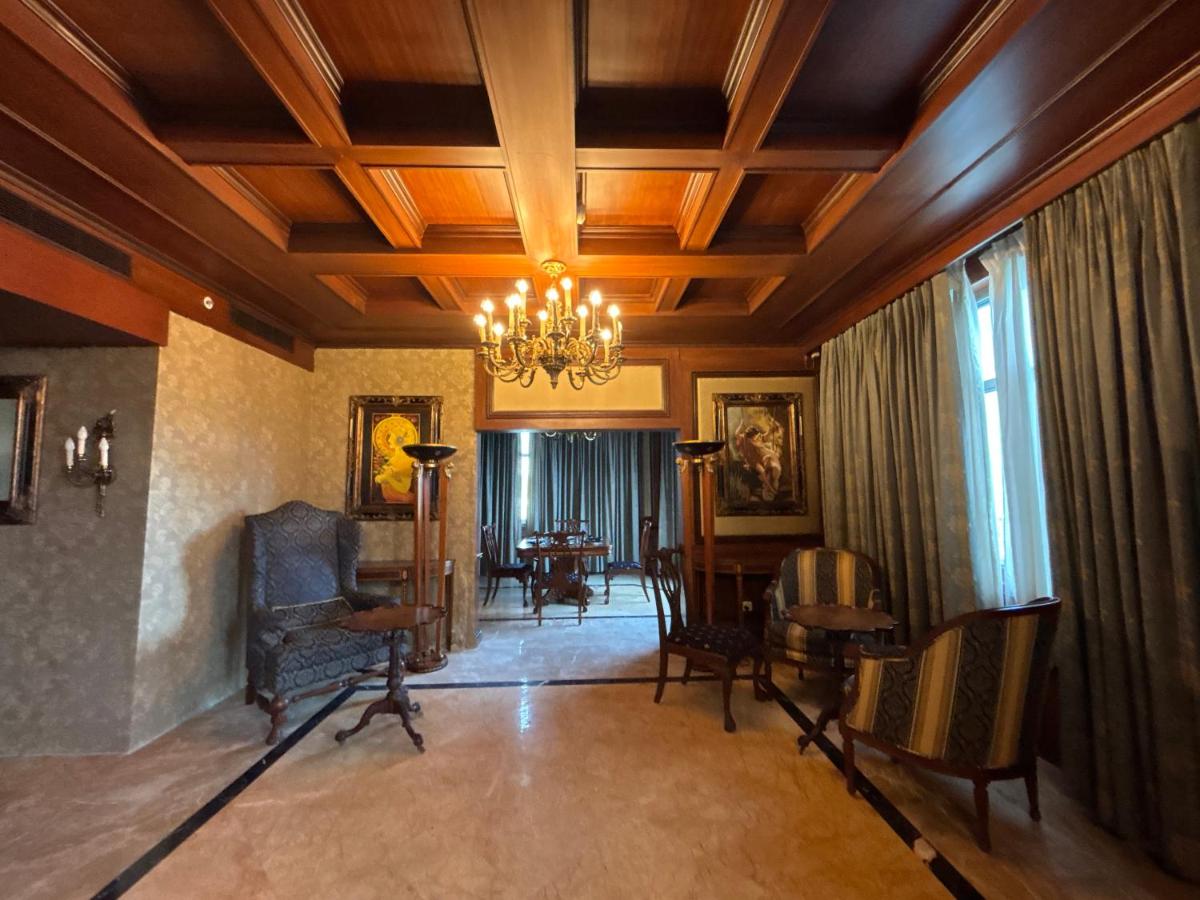 a living room with a chandelier and a table and chairs at Le Royal Meridien Chennai in Chennai