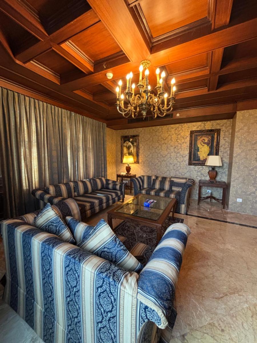 a living room with couches and a chandelier at Le Royal Meridien Chennai in Chennai