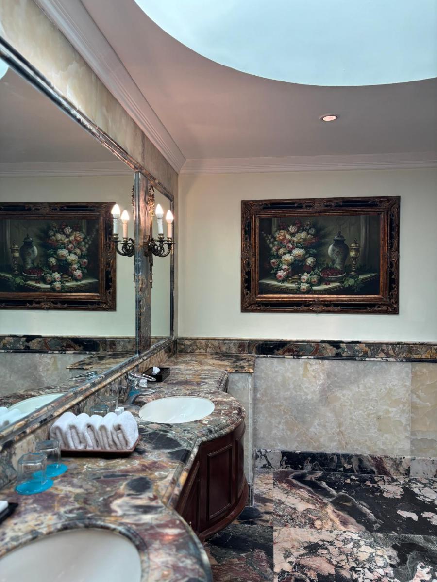 a bathroom with two sinks and a large mirror at Le Royal Meridien Chennai in Chennai