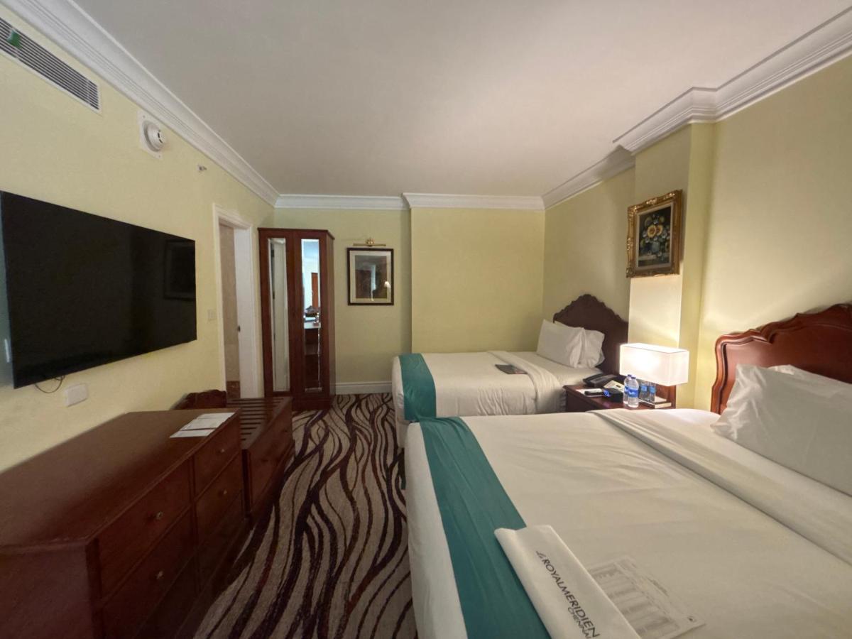 a hotel room with two beds and a flat screen tv at Le Royal Meridien Chennai in Chennai