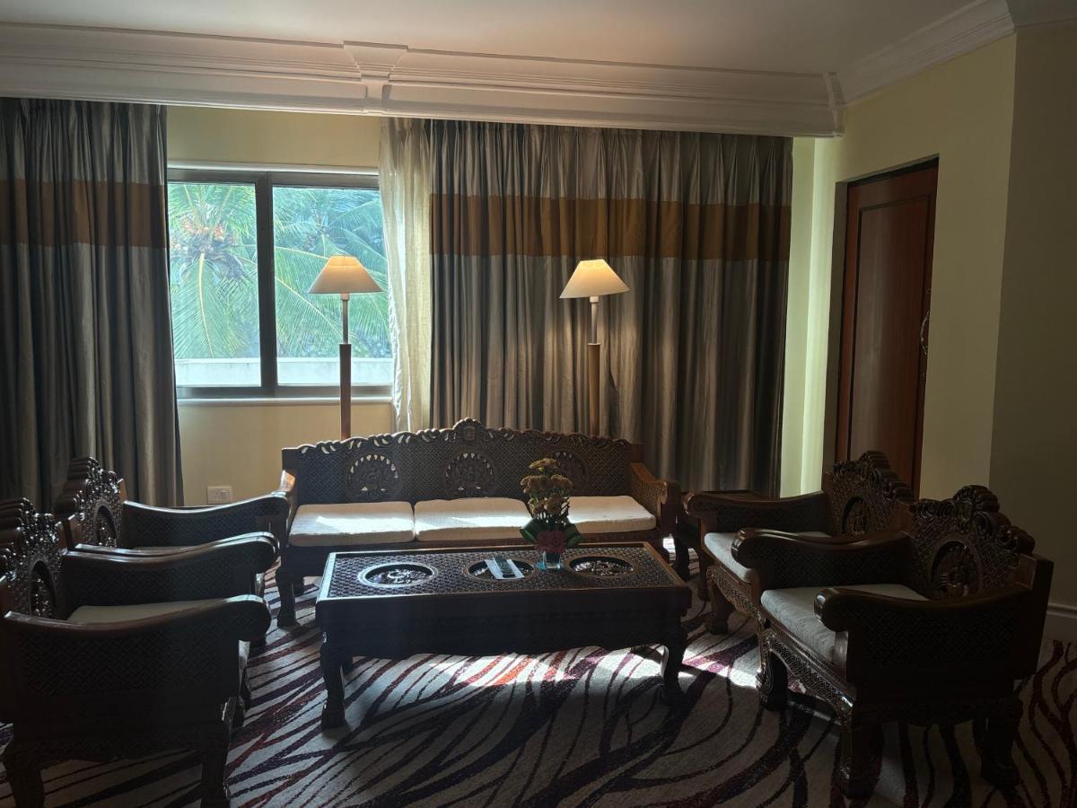 a living room with a couch and a table and chairs at Le Royal Meridien Chennai in Chennai