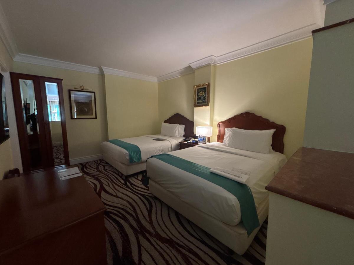 a hotel room with two beds and a bathroom at Le Royal Meridien Chennai in Chennai