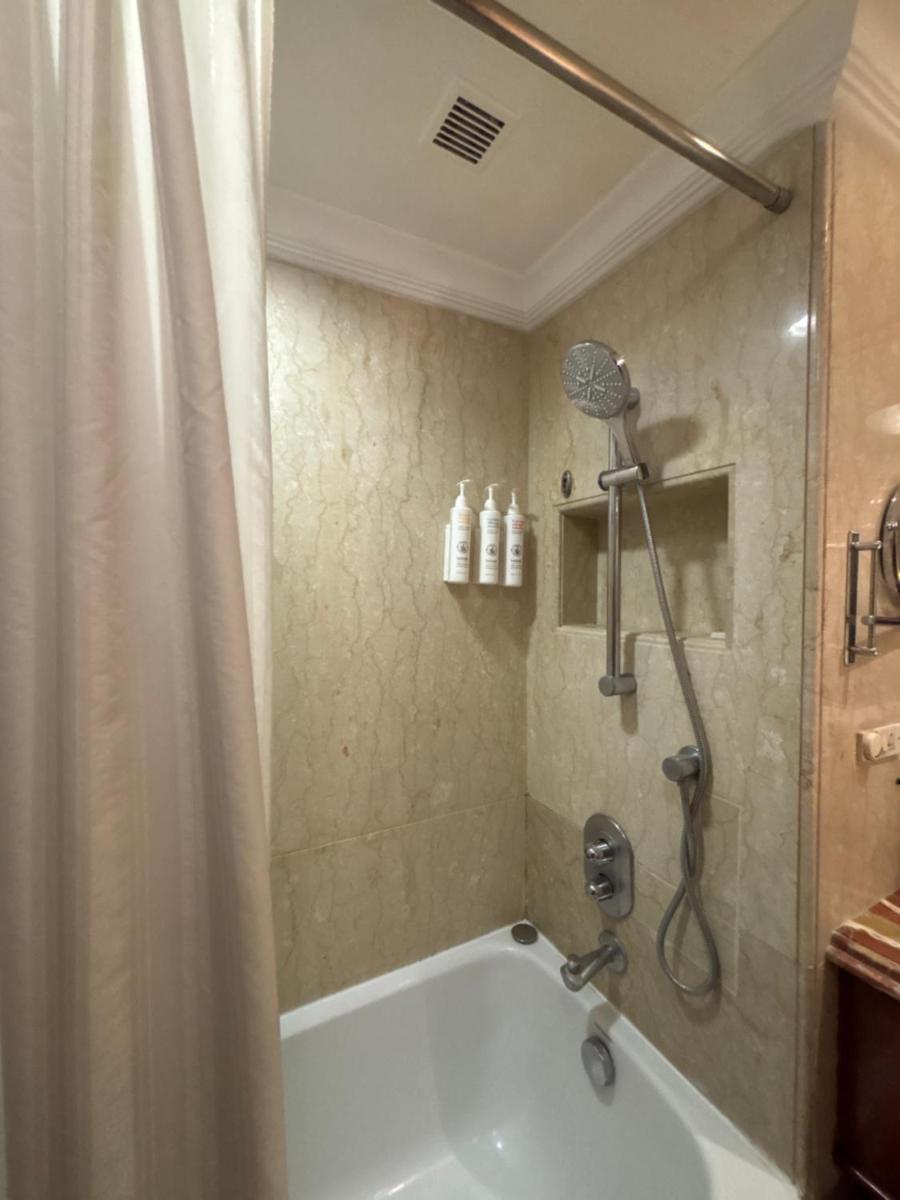 a bathroom with a shower and a bath tub at Le Royal Meridien Chennai in Chennai