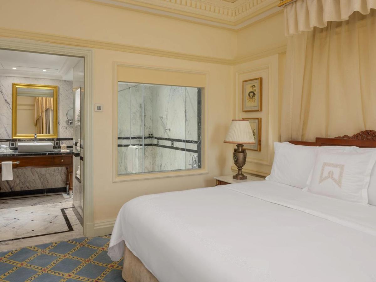 a bedroom with a large bed and a bathroom at ITC Windsor, a Luxury Collection Hotel, Bengaluru in Bengaluru a bedroom with a large bed and a bathroom at ITC Windsor, a Luxury Collection Hotel, Bengaluru in Bengaluru