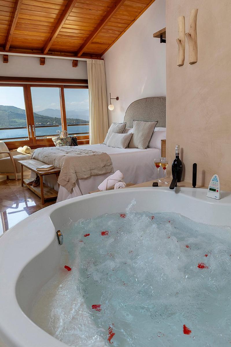 una bañera en una habitación con dormitorio en Hotel Spa Porto Cristo, en Port de la Selva