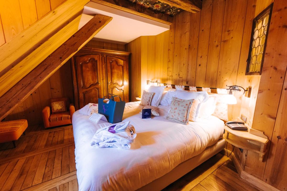 Un ou plusieurs lits dans un hébergement de l'établissement Les Violettes Hotel & Spa