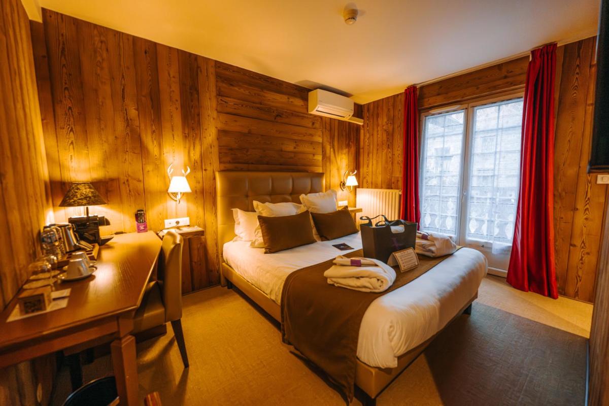 Un ou plusieurs lits dans un hébergement de l'établissement Les Violettes Hotel & Spa