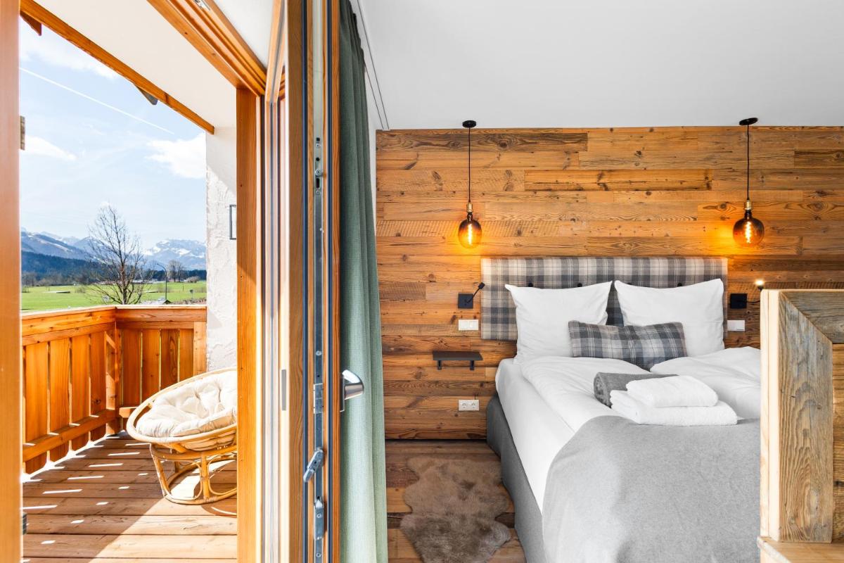 ein Schlafzimmer mit einem großen Bett auf einem Balkon in der Unterkunft Soho Mountain Chalet - Pool und Sauna in Reit im Winkl