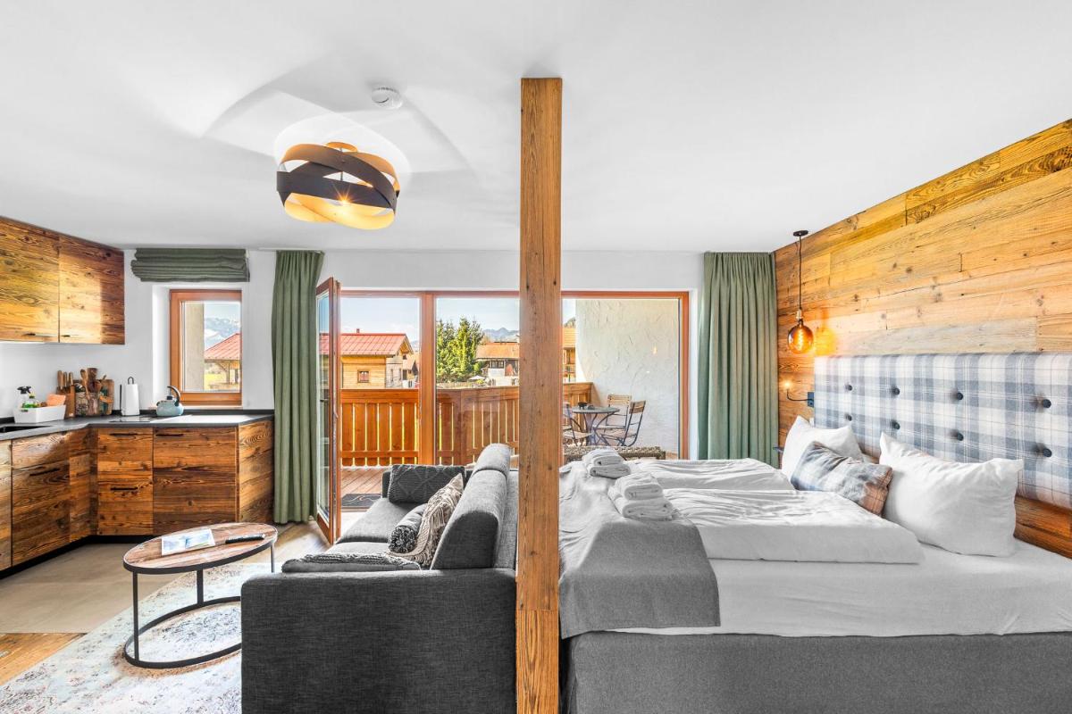 ein Schlafzimmer mit Bett und ein Wohnzimmer in der Unterkunft Soho Mountain Chalet - Pool und Sauna in Reit im Winkl