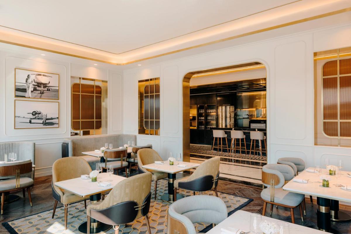 a restaurant with tables and chairs and a bar at Fairmont Mumbai in Mumbai