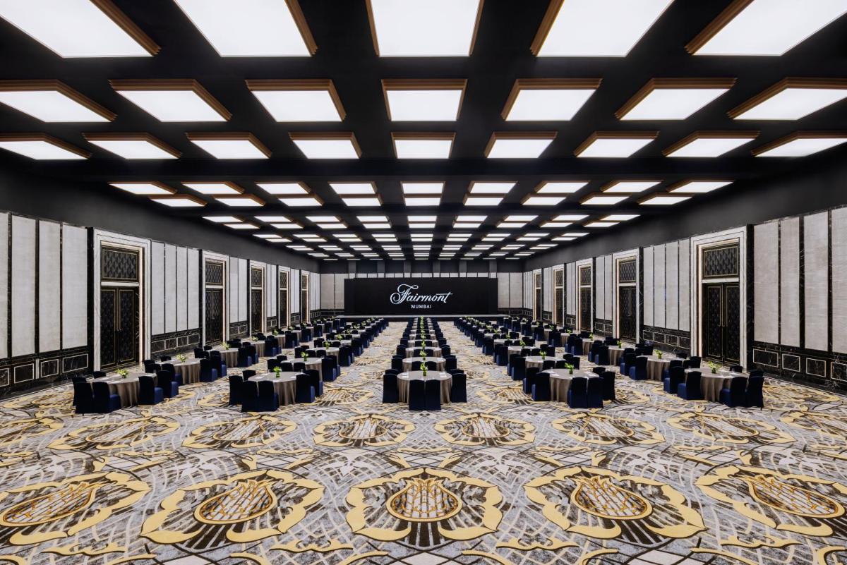 a large banquet hall with tables and chairs on a carpet at Fairmont Mumbai in Mumbai