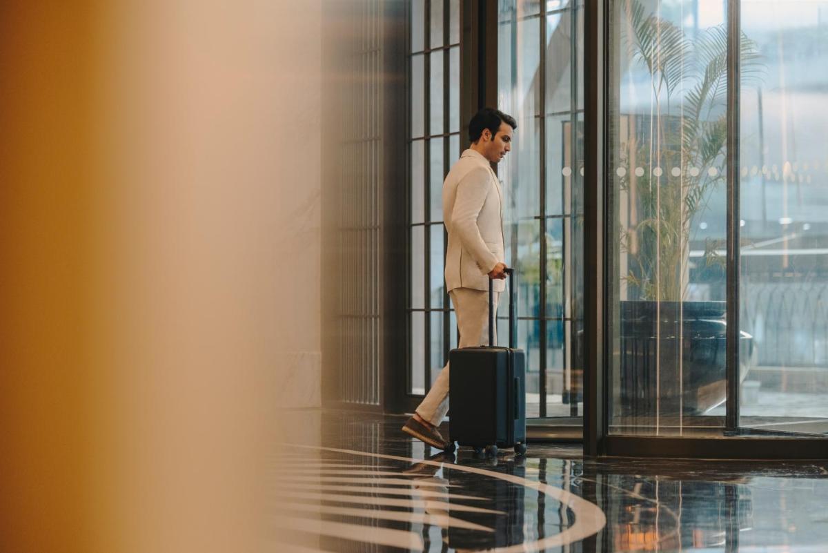 a man standing with a suitcase in a building at Fairmont Mumbai in Mumbai