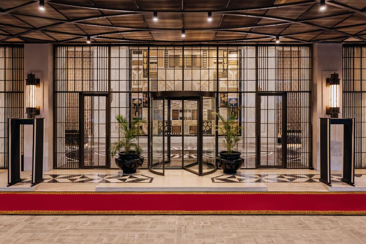 a lobby with potted plants in front of a window at Fairmont Mumbai in Mumbai
