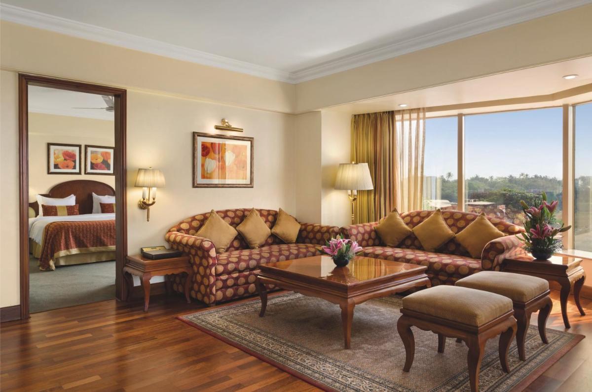 a living room with a couch and a bed at Ramada Plaza By Wyndham Palm Grove in Mumbai