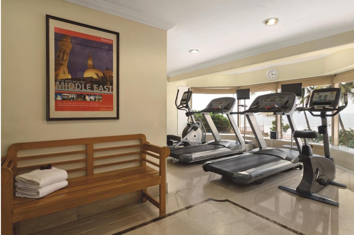 a gym with several tread machines in a room at Ramada Plaza By Wyndham Palm Grove in Mumbai