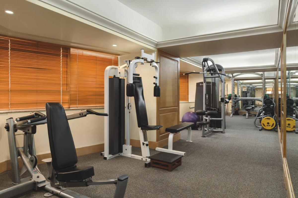 a gym with treadmills and machines in a room at Ramada Plaza By Wyndham Palm Grove in Mumbai