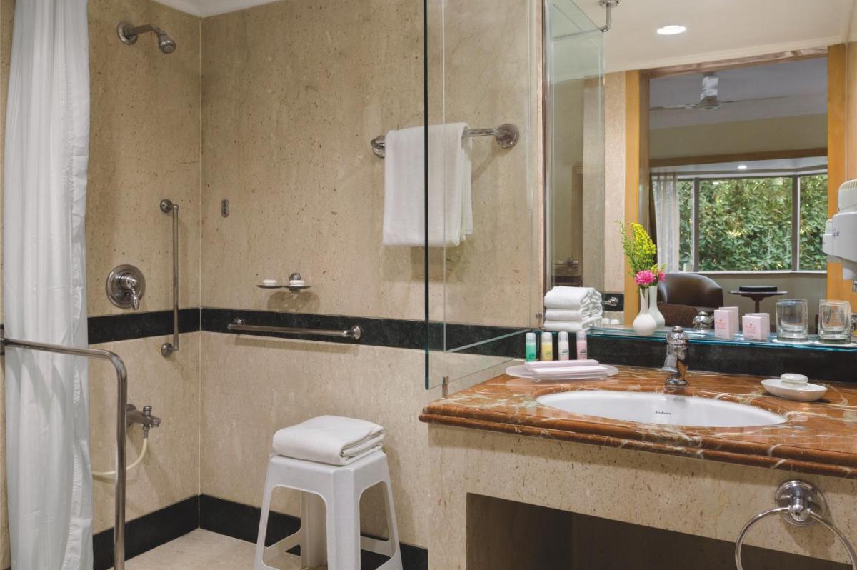 a bathroom with a sink and a shower at Ramada Plaza By Wyndham Palm Grove in Mumbai