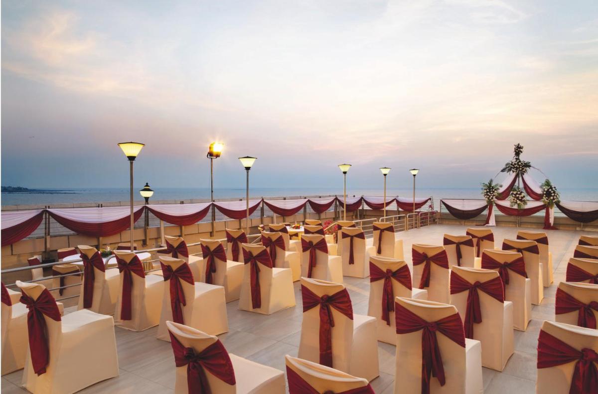 a set up for a party on the beach with bows at Ramada Plaza By Wyndham Palm Grove in Mumbai