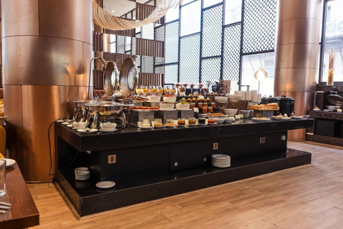 a buffet line with food on display in a restaurant at Holiday Inn Kolkata Airport by IHG in Kolkata