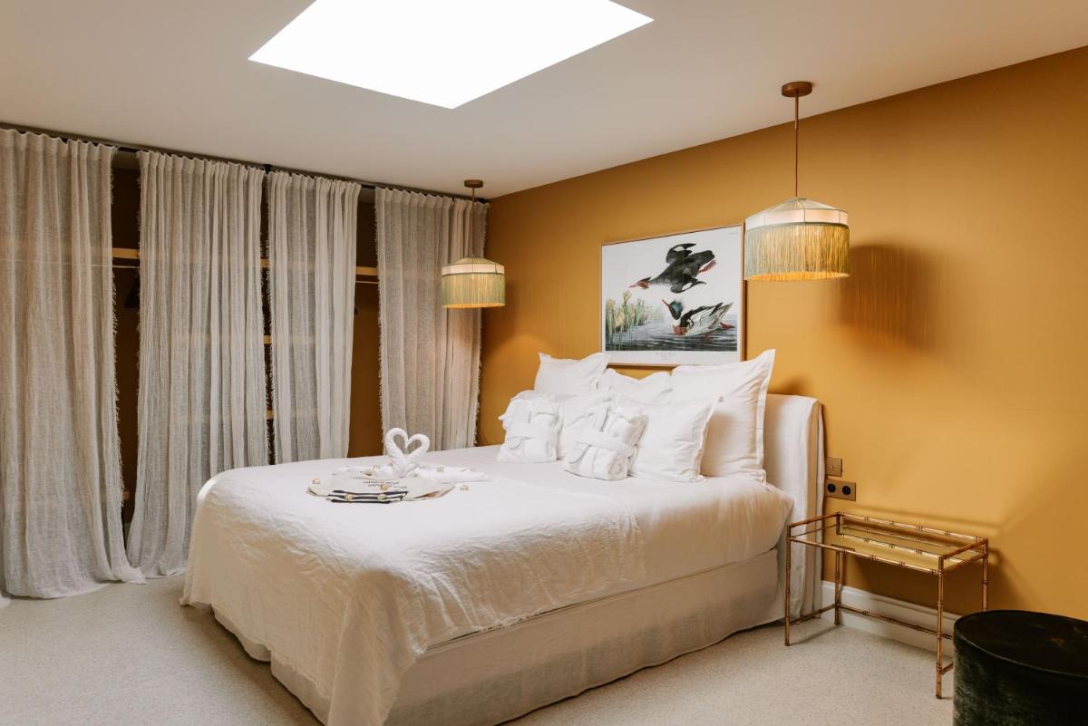 - une chambre avec un grand lit blanc et des oreillers blancs dans l'établissement Château de Théoule, à Théoule-sur-Mer