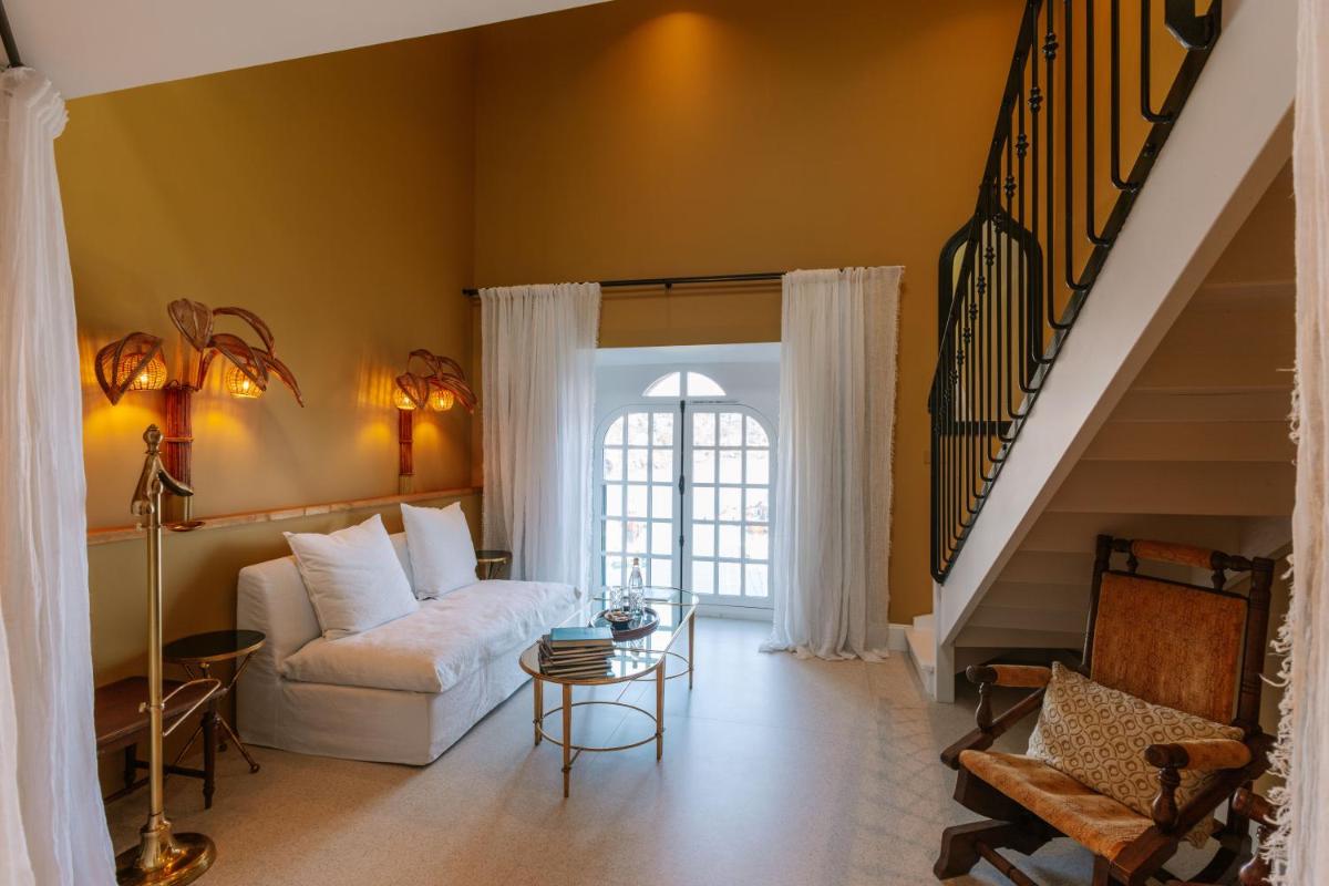 - un salon avec un canapé blanc et un escalier dans l'établissement Château de Théoule, à Théoule-sur-Mer