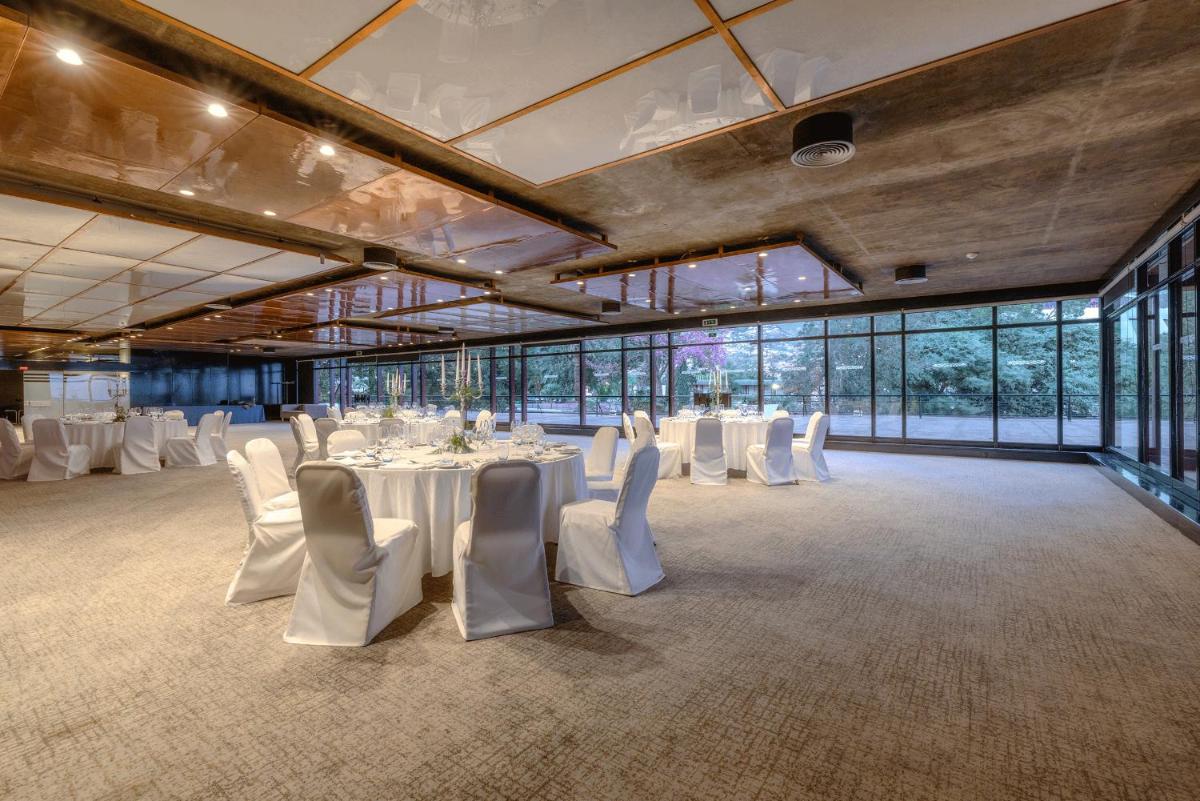 um salão de banquetes com mesas, cadeiras e janelas brancas em Pestana Casino Park Hotel & Casino no Funchal mais 42 fotografias