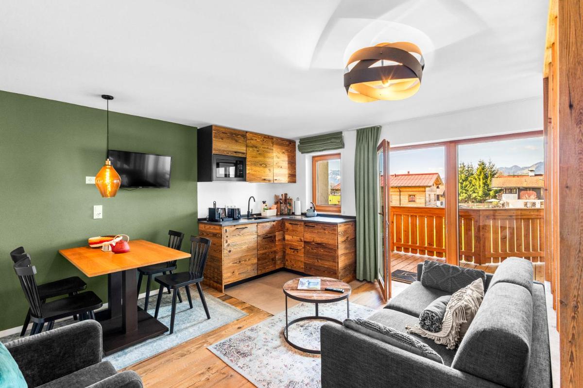 ein Wohnzimmer mit Couch und Tisch in der Unterkunft Soho Mountain Chalet - Pool und Sauna in Reit im Winkl