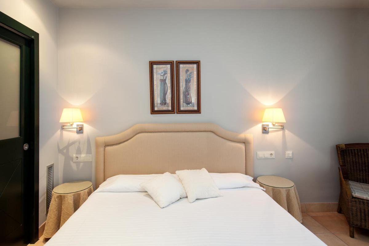 Un dormitorio con una cama blanca con dos almohadas. en Apartahotel Suites Vila Birdie, en Navata