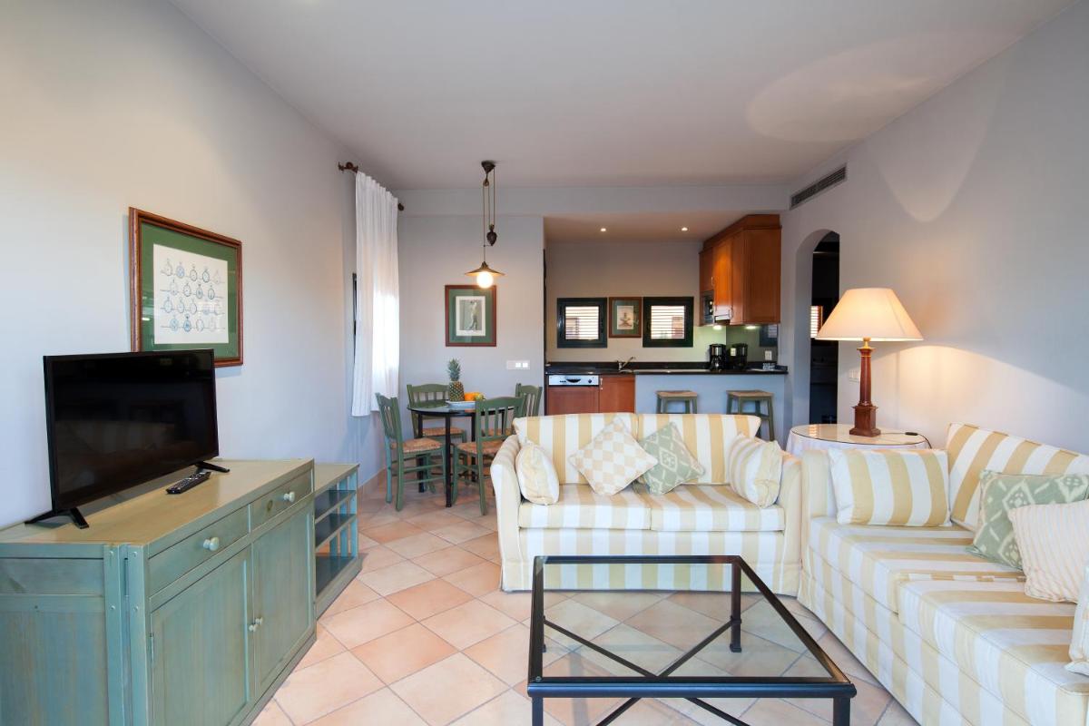 Una sala de estar con dos sofás y un televisor. en Apartahotel Suites Vila Birdie, en Navata
