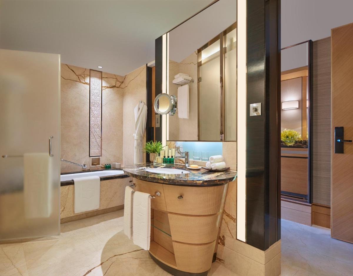 a bathroom with a large sink and a tub at Shangri-La Bengaluru in Bengaluru a bathroom with a large sink and a tub at Shangri-La Bengaluru in Bengaluru