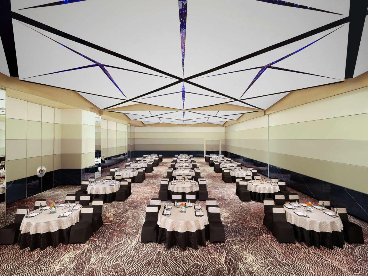 a large banquet hall with tables and chairs at Novotel New Delhi City Centre in New Delhi a large banquet hall with tables and chairs at Novotel New Delhi City Centre in New Delhi
